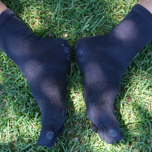 Close-up of black five-toe grip socks feet together