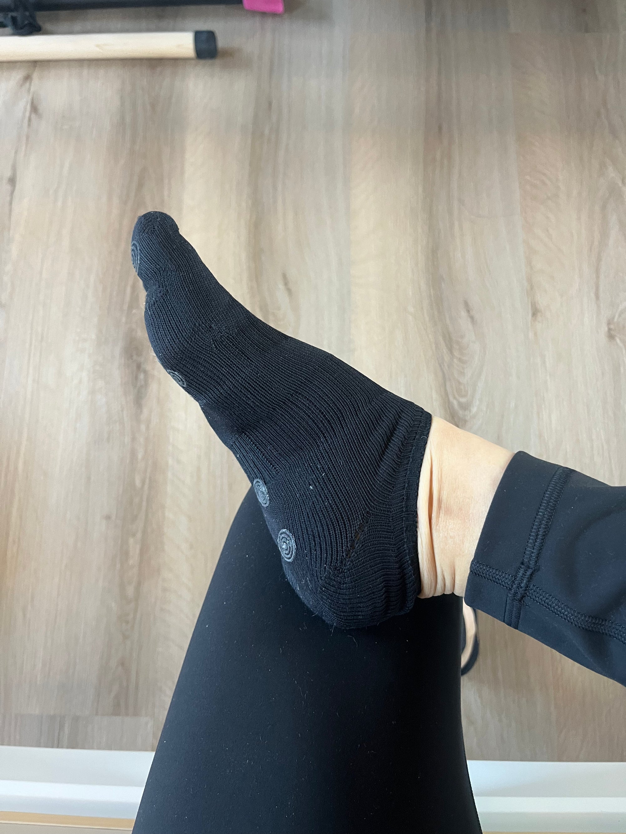 Person wearing black five-toe ankle grip socks with breathable fabric