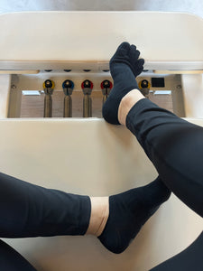 V+Force black five-toe grip socks worn during workout for stability and grip